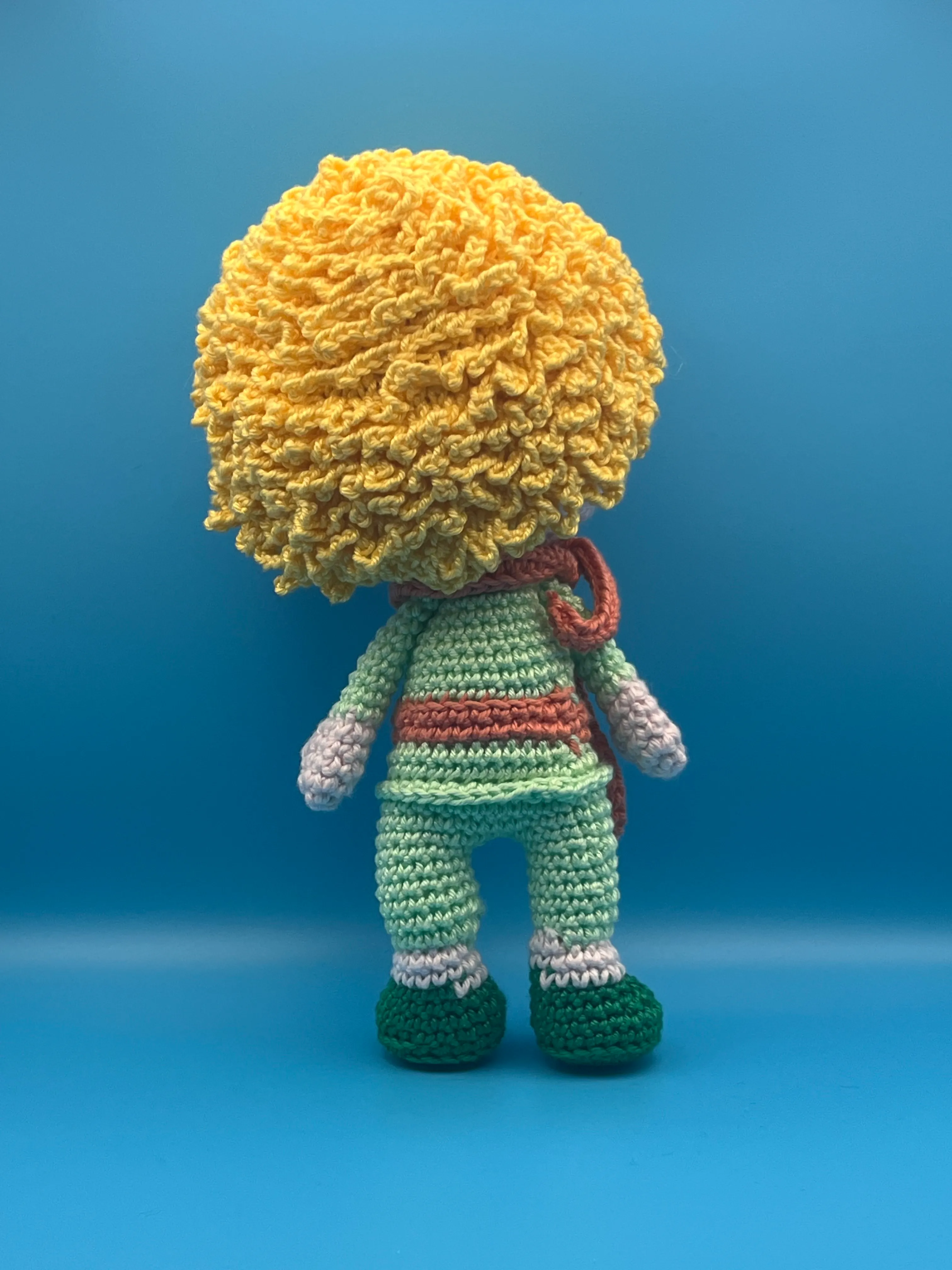 Close view of the Little Prince’s embroidered face and green costume