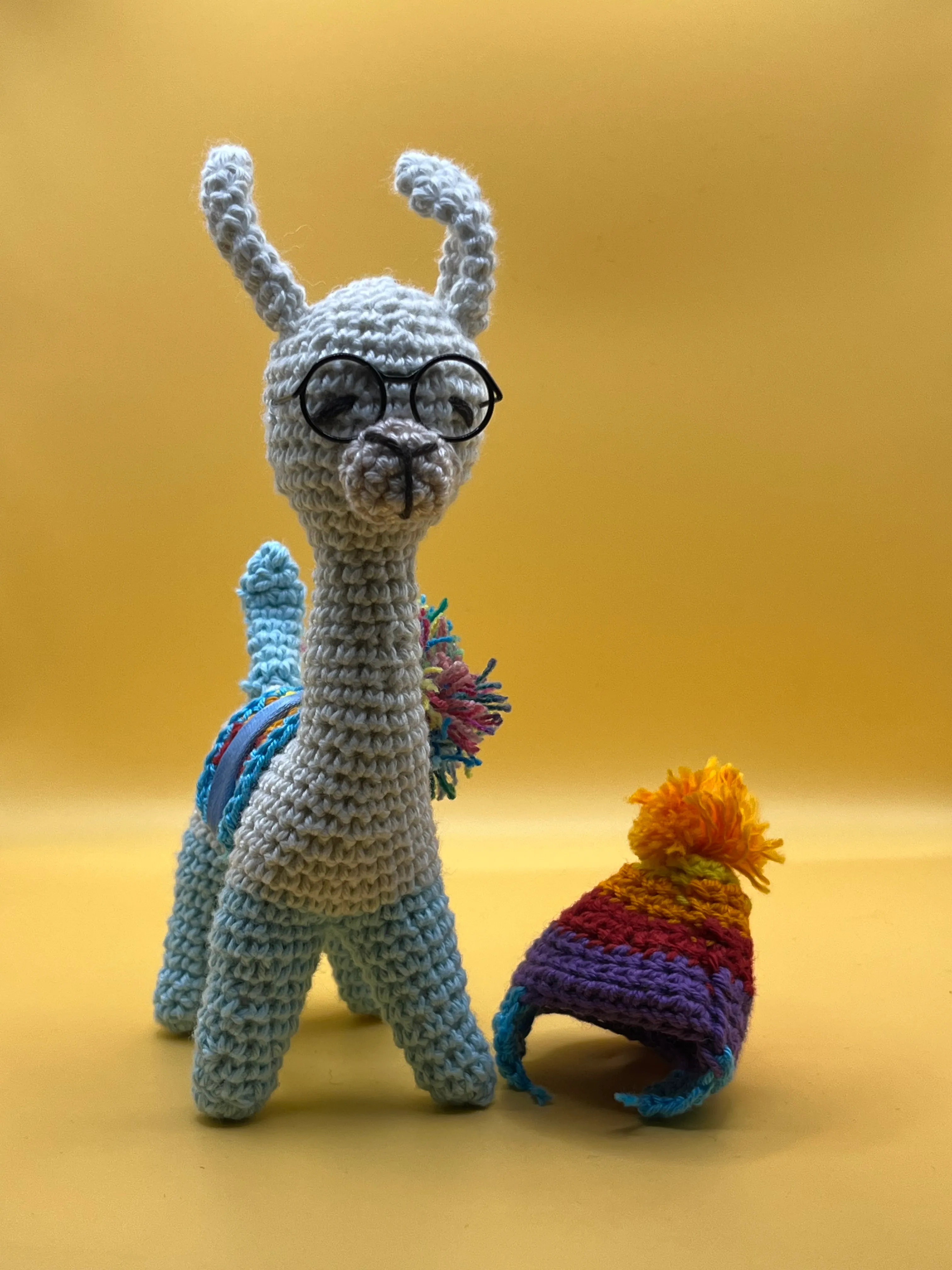 Close view of the llama’s embroidered face and striped scarf