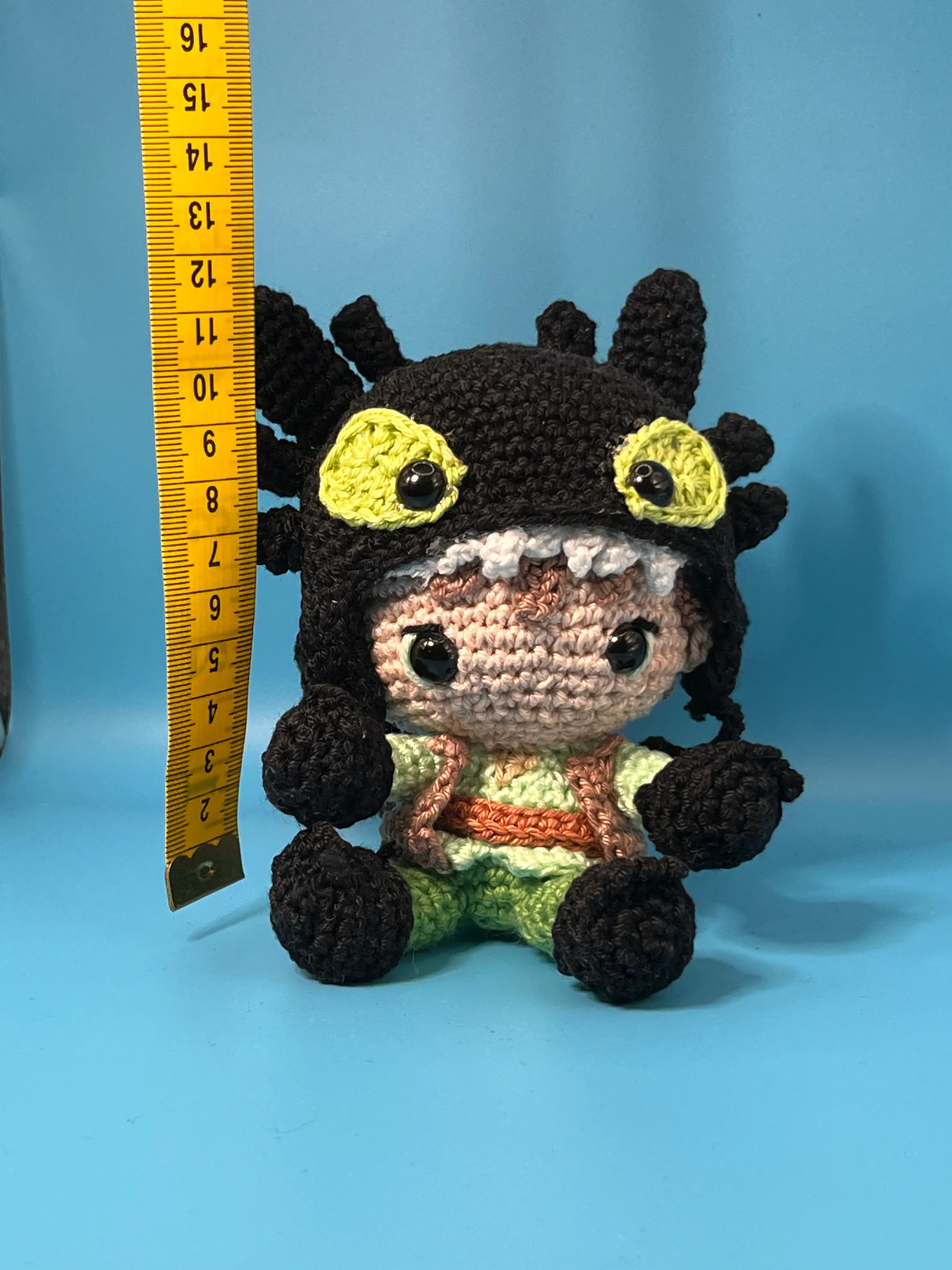 Hiccup amigurumi posed in an illustrated dragon setting