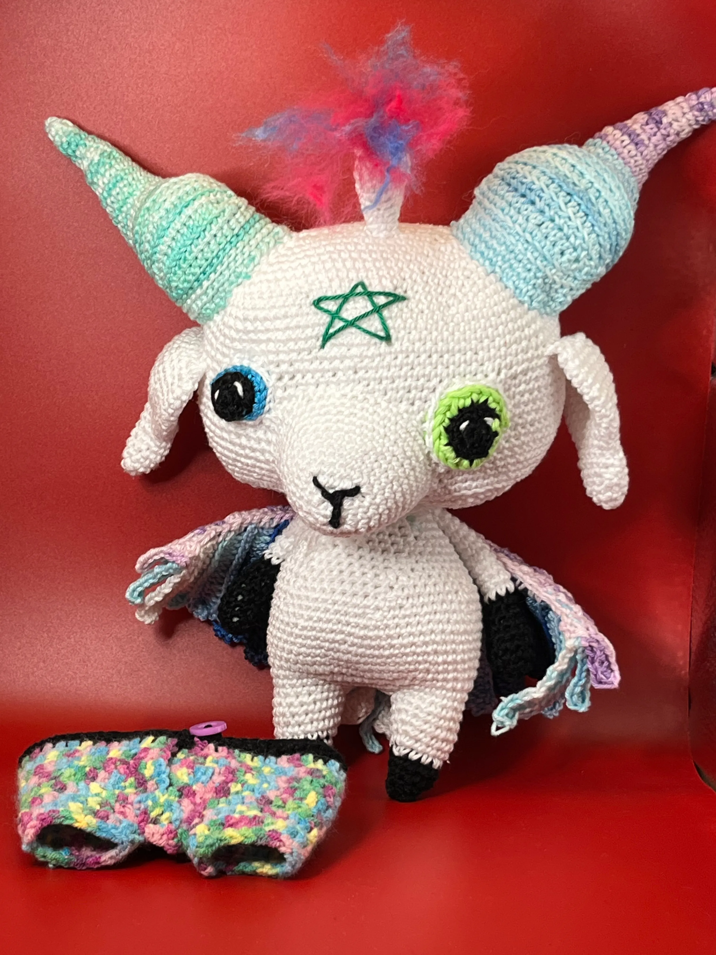 Baphomet amigurumi photographed against a dark magical background