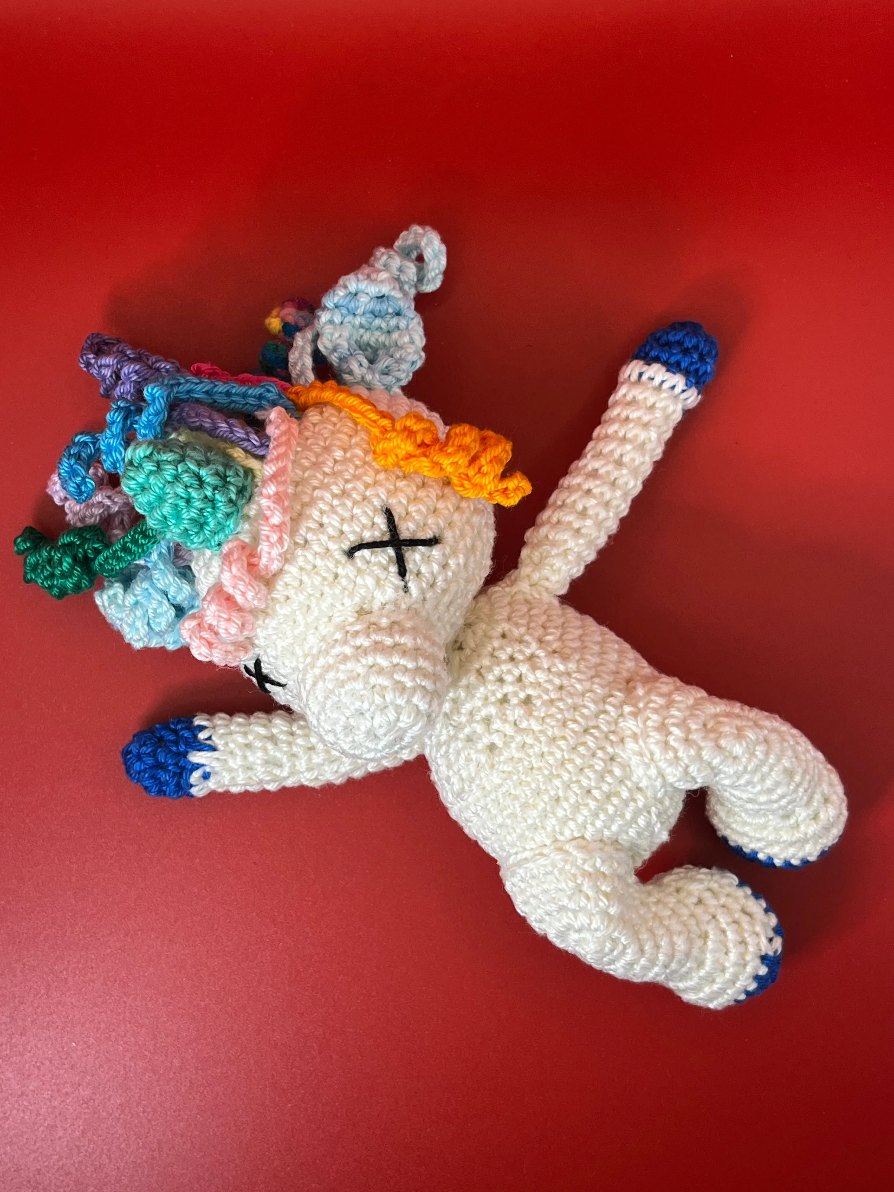 Strafattino unicorn resting against a red background