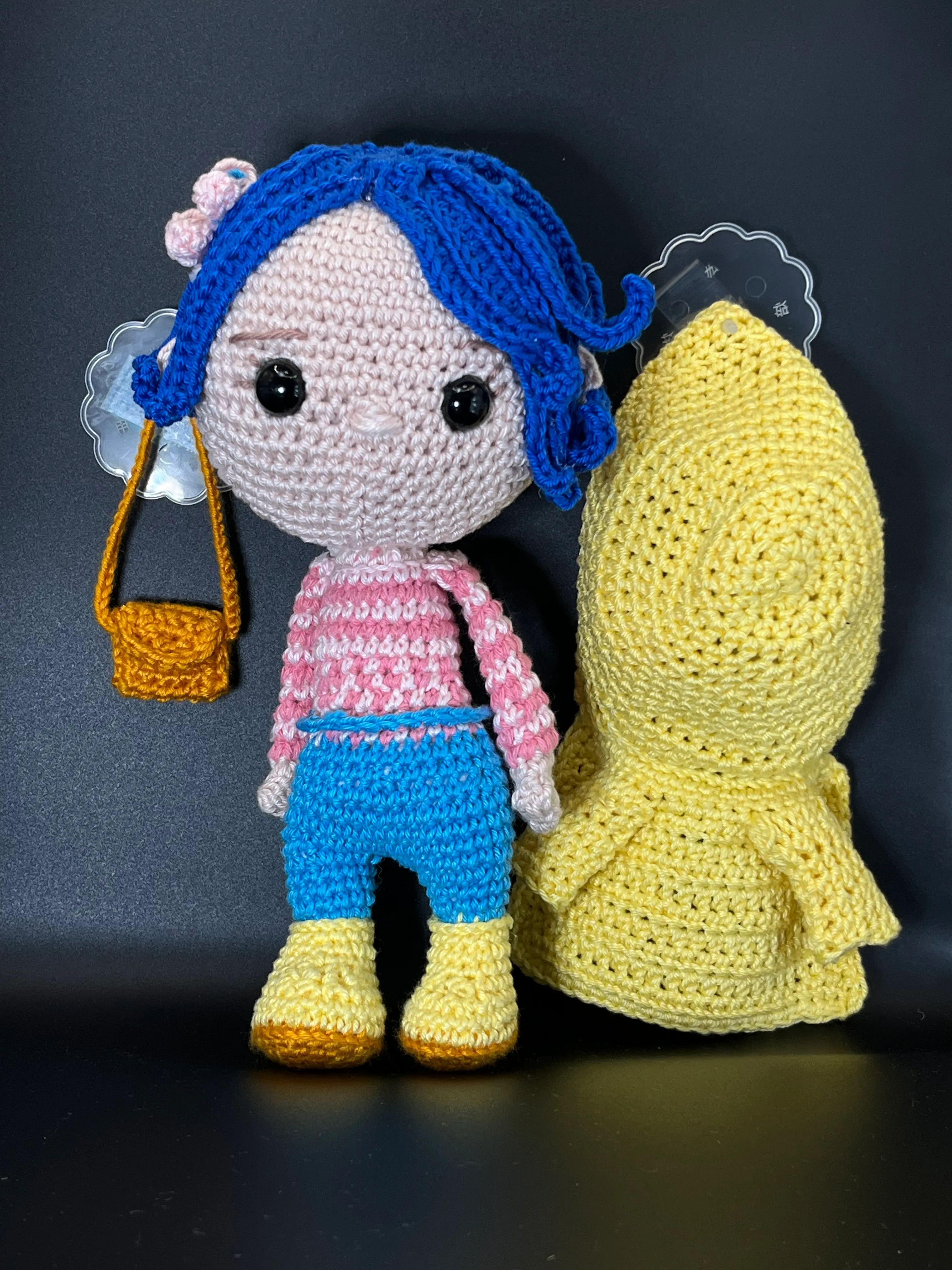Coraline amigurumi photographed against a dark storybook setting