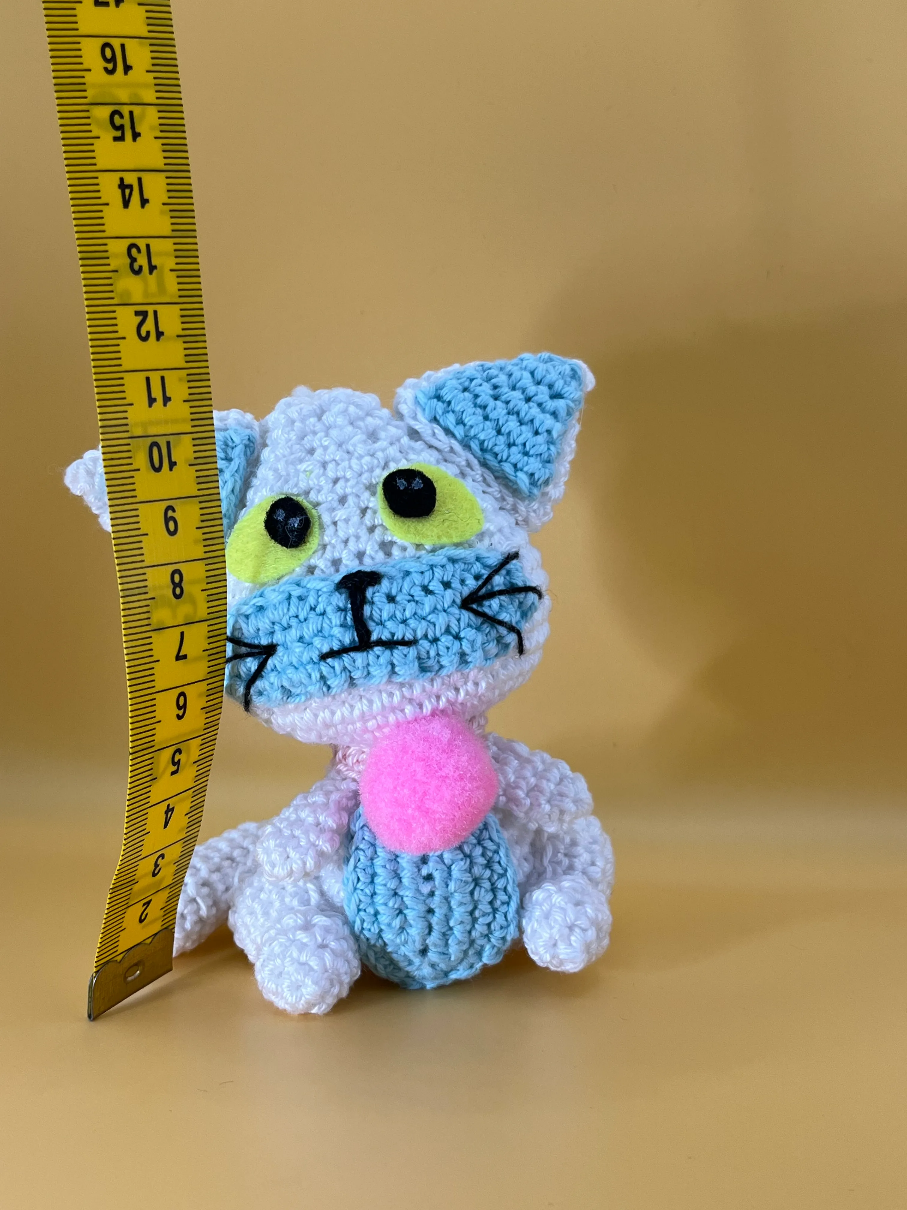 Posi amigurumi photographed on a warm neutral background