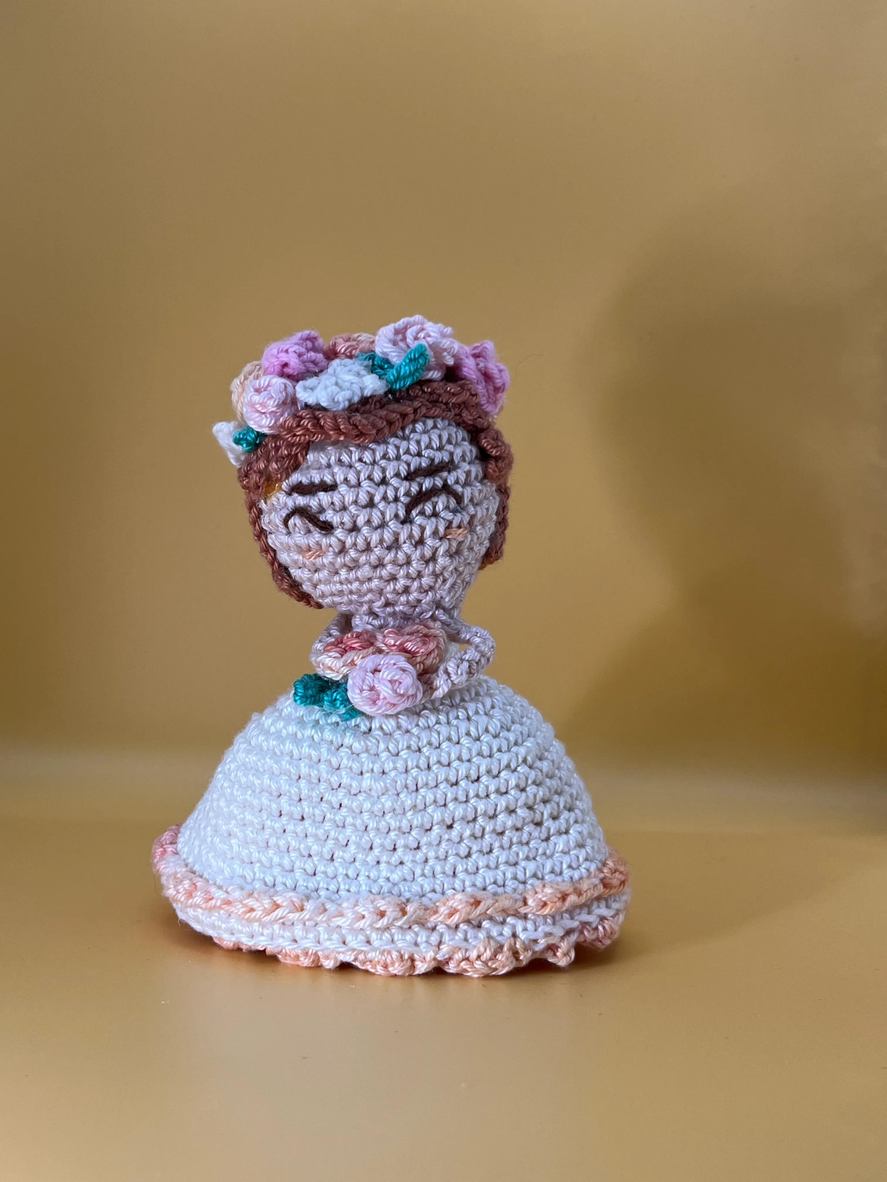 Front view of the bridesmaid’s embroidered face, floral crown, and white dress