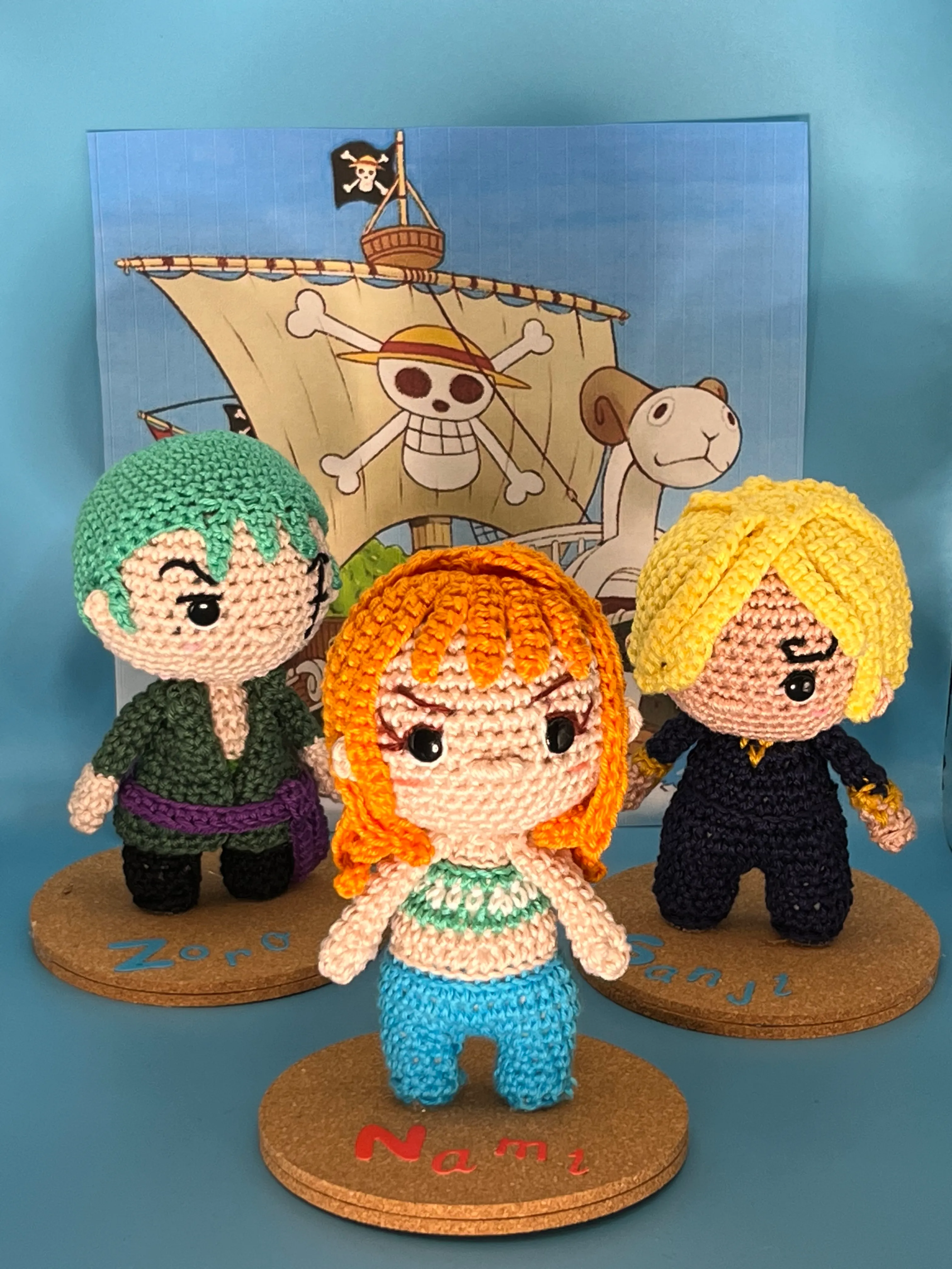 Crocheted figures of Zoro, Nami, and Sanji arranged together